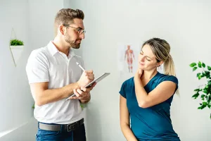 Physio-medicine London physiotherapist assessing patient with neck pain.